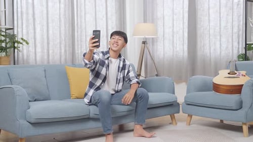 Young Adult on Couch Using Smartphone for Video Call