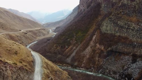 Vast Golden Mountain Landscape with Distant Snow-Capped Peaks