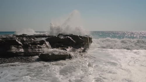 Waves Crash Against a Rocky Shoreline, Sending Water into the Air. The Dynamic Motion of the Waves