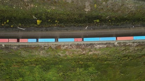 Train with Freight Cars Rides on Railroad Transportation and Delivery of Cargo in Containers Between