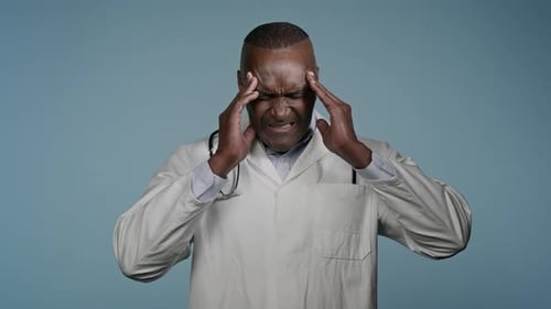 Unhappy African American Man Doctor Male Healthcare Employee Medical Worker in Blue Studio Feeling