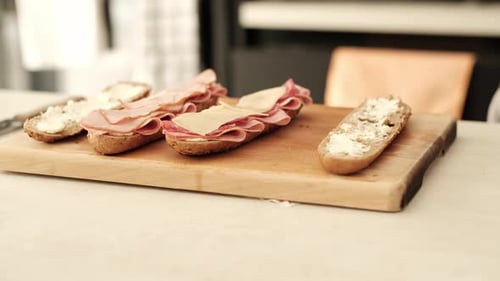 Man Prepares Meat and Cheese Sandwiches