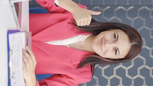 Friendly Woman at Office Desk Gives Thumbs Up