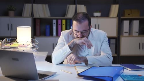 Geschäftsmann, der nachts arbeitet und sich schläfrig fühlt.