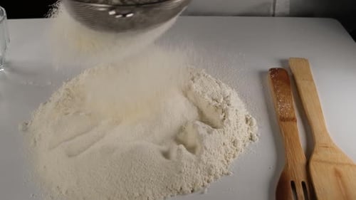 Sifting Flour for Baking on White Surface