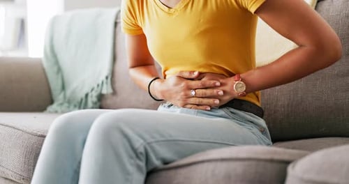 Pain, period and hands of woman on stomach holding belly for cramps, ache and menstruation problem
