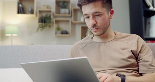 Close Up of Caucasian Man Sitting on Cozy Sofa in Living Room and Working on Laptop Male Working As