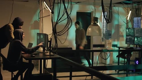 Hackers Working on Computers in Dark Office