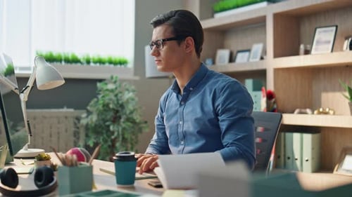 Schöner Freelancer, der am Computer tippt, im Büro arbeitet, Nahaufnahme, Mann surft online