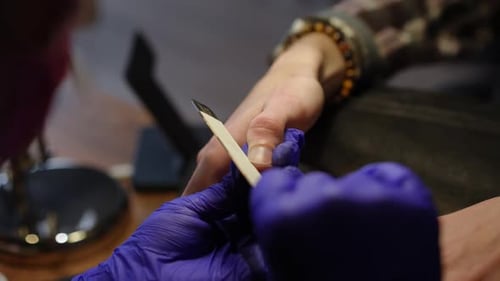 Closeup Manicurist Filing Nails of Unrecognizable Young Caucasian Man in Beauty Salon High Angle