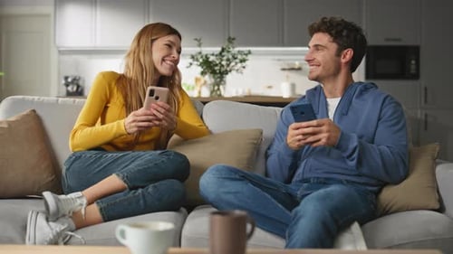 Couple Using Cell Phones Together on Sofa