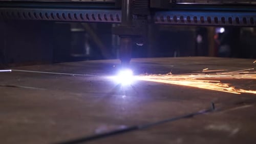 Schwerer industrieller Laser-CNC-Schneidbrenner schneidet Präparate aus Metall. Nahaufnahme