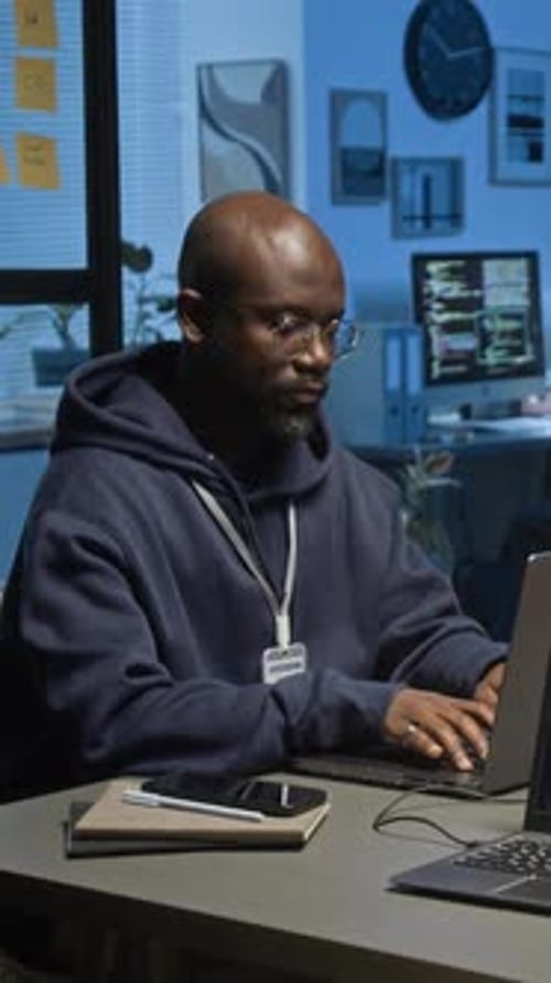 Man Working Late on Computer Code in Office