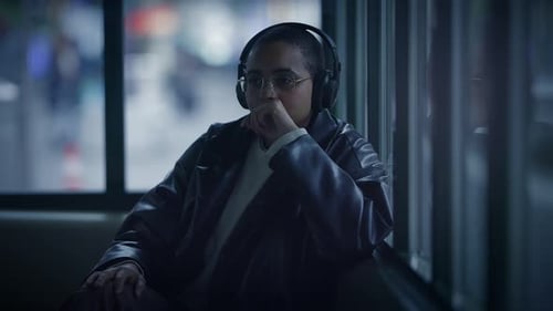 Woman with Headphones Rides Public Transit at Night