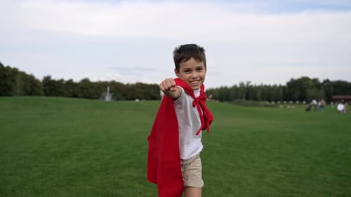 Happy Boy in Red Cape Pretending Superman