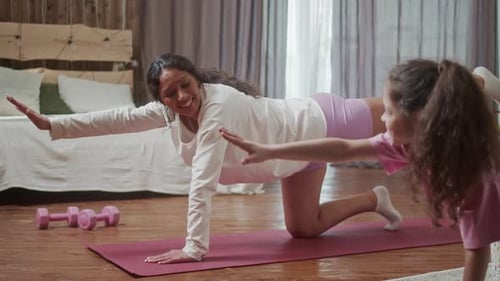Woman and Girl Doing Yoga Exercise at Home