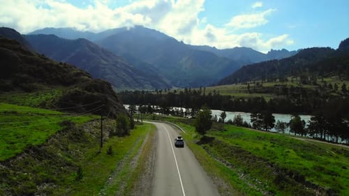 Aerial View of a Car Driving on a Scenic Mountain Road Media