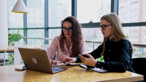 Women Collaborating on Laptop in Modern Office