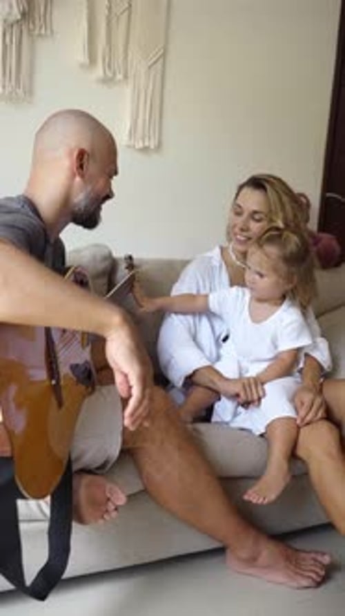 Father Playing Guitar for His Family at Home