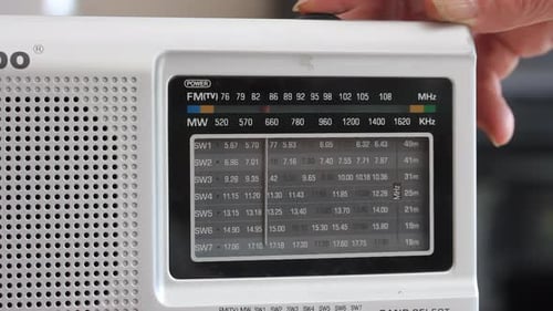 Female Hand Tuning an Old Radio Receiver.