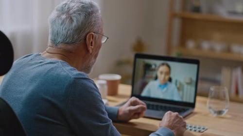 Back View Retired Old Man Holding Video Call Conversation Consulting with Female Doctor
