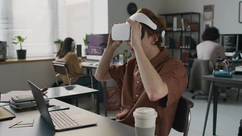Young Adult Using Virtual Reality Headset at Desk