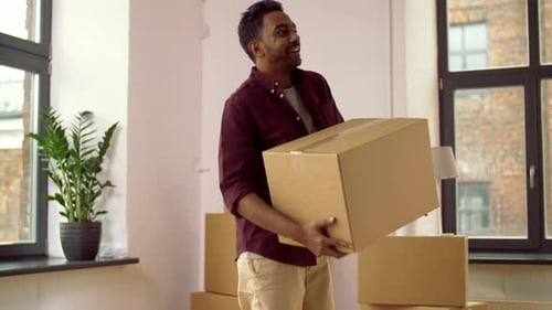Man Carrying Cardboard Box in New Home