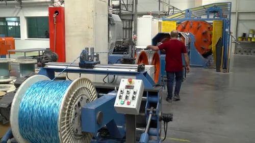Man Working with Wire Spooling Machine in Factory