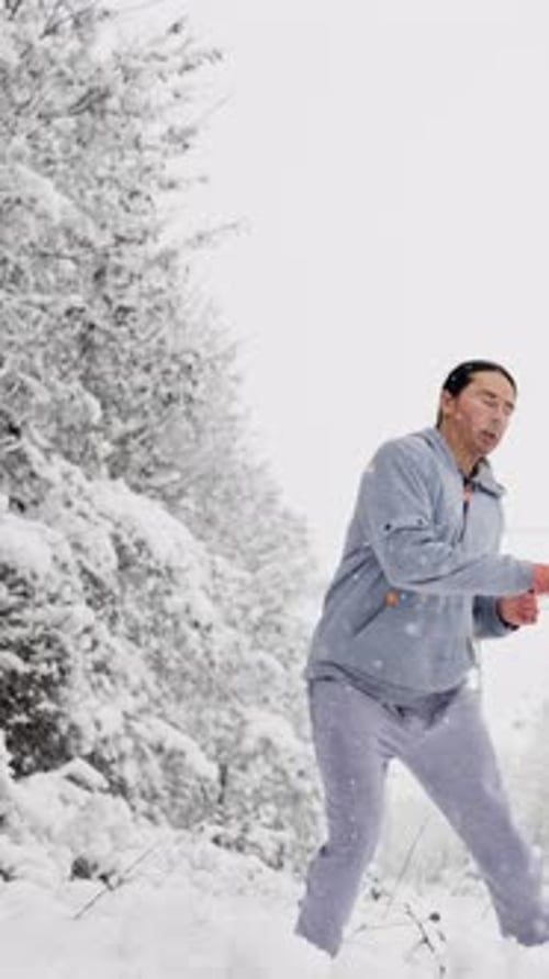 Man Doing a Side Kick in Snowy Landscape