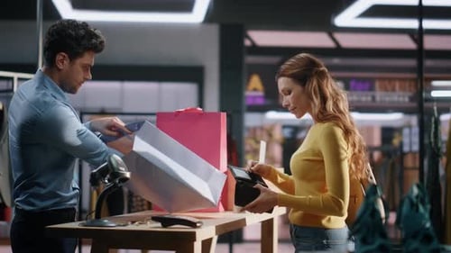 Sales Man Putting Purchases Bag in Clothing Store Closeup Joyful Lady Buy Items