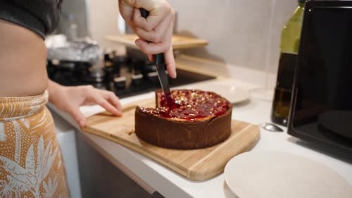 Woman Cuts a Slice of Tasty Cheesecake