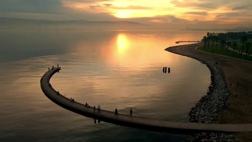 A group of people are walking on a bridge over a body of water