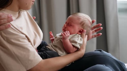 Mother Cradles Sleeping Infant in Peaceful Home Setting