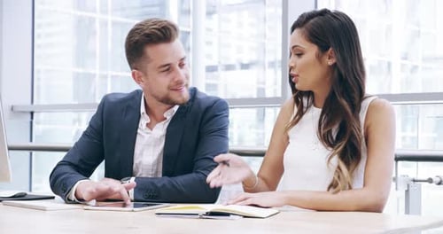 4k video footage of two young business colleagues working together in their office