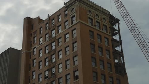 A mid-demolition view of a high-rise building in Youngstown, Ohio, showing the upper floors partiall