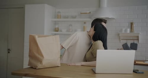 Couple Unpacking Groceries Together in Bright Kitchen