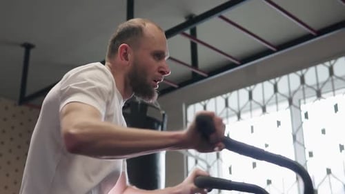Man Works Out Hard in Gym