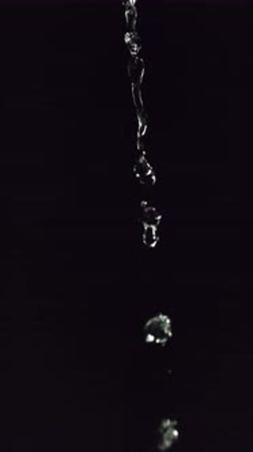 Water Droplets Falling on Dark Background