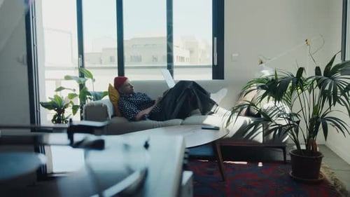 Young Adult Works On Laptop At Home