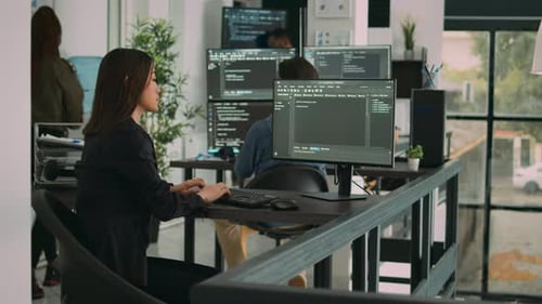 Ingénieur logiciel asiatique travaillant avec une interface utilisateur sur un écran d'ordinateur