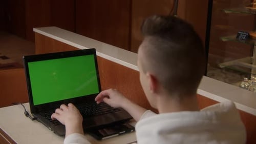 Back view business man working on laptop with green screen.Young man working at the computer