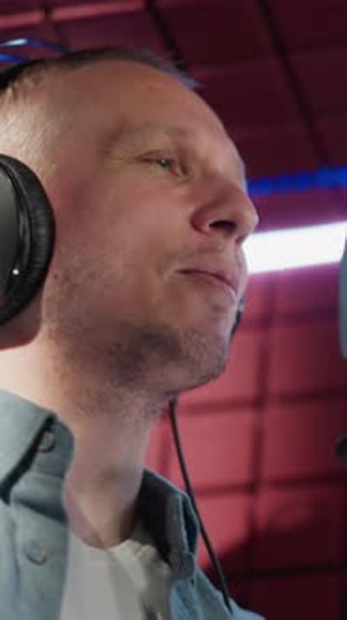 Homme chantant en studio d'enregistrement avec fond de panneau acoustique