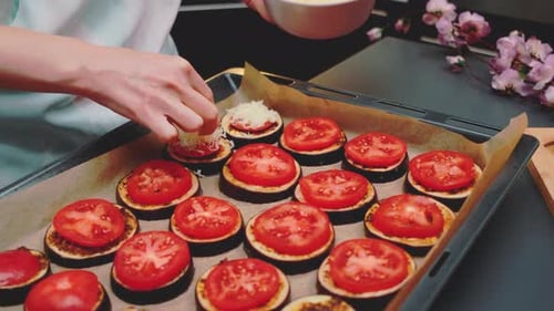 Étendre du fromage râpé sur des tomates avec des aubergines
