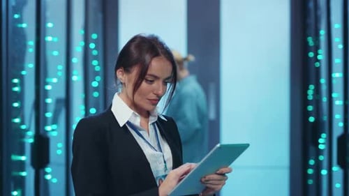 Eine selbstbewusste Frau in einem Serverraum zeigt ihr technisches Fachwissen