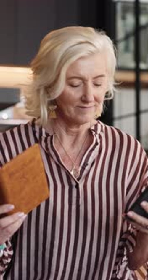 Smiling Woman Holds Passport and Looks at Phone