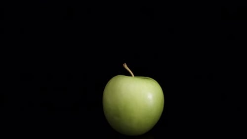 green apple on black background, camera zoom, macro video