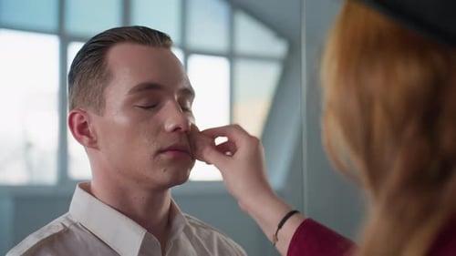 Man Getting Make-up Applied With Sponge in Studio