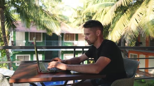 Travail indépendant au Outdoor Palm Cafe Un homme utilise un ordinateur Emploi indépendant