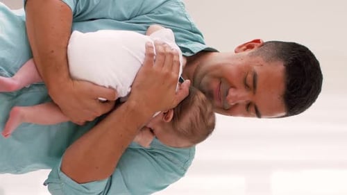 Father Holds Infant in his Arms