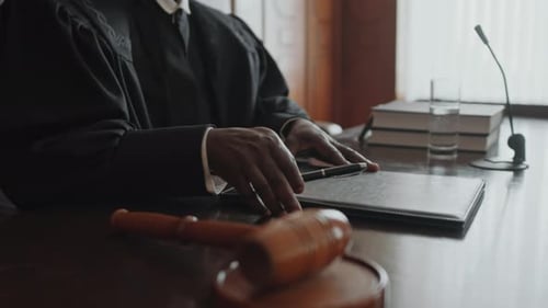 Male Judge Hitting Sound Block with Gavel and Starting Court Trial